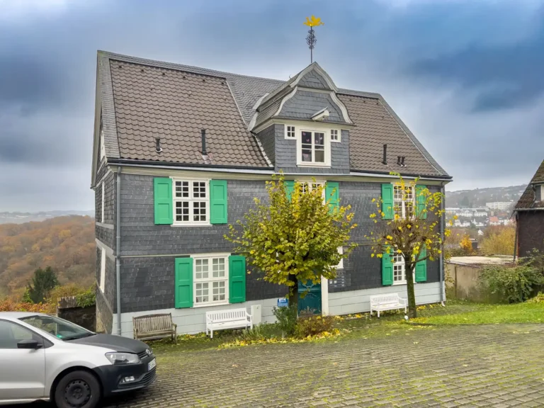 Historisches Schieferhaus mit grünen Fensterläden in Hanglage über dem Tal, betreut von VALOGIS Immobilienmakler Solingen | Haus verkaufen in Solingen